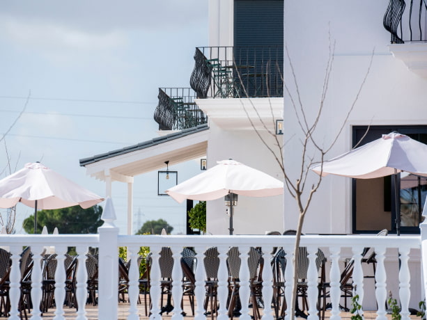 Terraza de Los Molinillos Terraza equipa con mesas, sillas y elegantes sombrillas